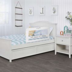 a white day bed with drawers underneath it in a room that has wood flooring