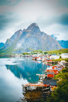 an island with many houses and mountains in the backgrouds, surrounded by water