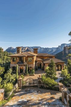 a large house surrounded by trees and mountains