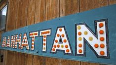 a wooden sign that says nathan on the side of a building with orange and white polka dots