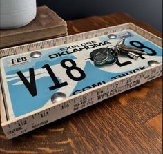 a close up of a wooden table with a ruler and keys on top of it