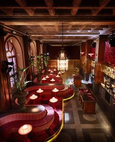 a dimly lit room with red couches and tables