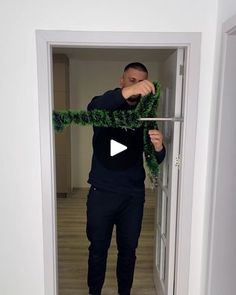 a man is opening the door to his apartment with a green ribbon around his neck