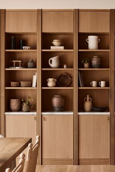 a wooden bookcase filled with lots of books and vases on top of it