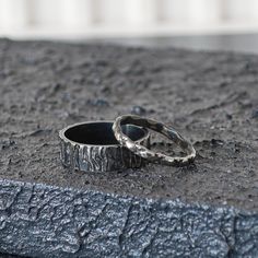 two wedding rings sitting on the ground next to each other