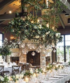 an image of a table setting with candles and greenery on the fireplace mantel