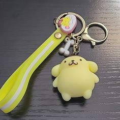 a yellow plastic key chain with a cartoon character on it and a bone in the shape of a dog