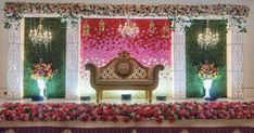 an elaborate stage set up with flowers and chandeliers for a wedding or reception