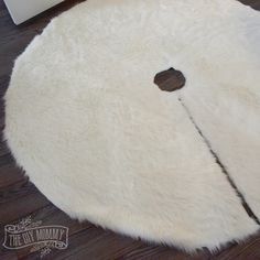 a white round rug with an apple cut in the middle on a wooden floor next to a radiator