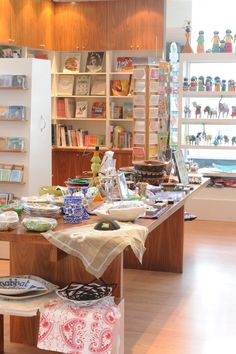 a table with plates and bowls on it in a room filled with shelves full of books