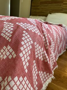 a bed with a red and white blanket on top of it