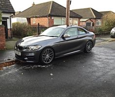 a grey car parked in front of some houses