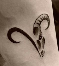 a black and white photo of a ram tattoo