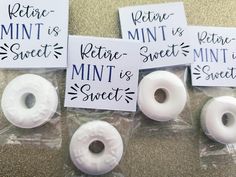 four white donuts sitting on top of each other in plastic bags with stickers attached to them