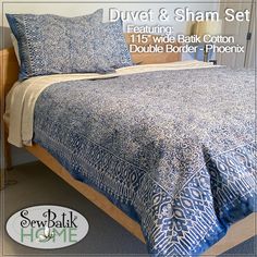 a bed with blue and white bedspread on it