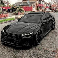 a black car parked in front of some houses