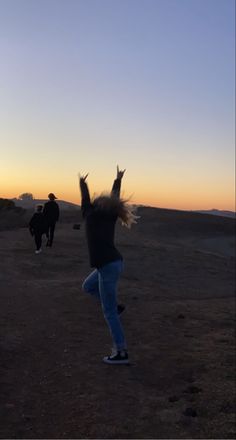 a person jumping in the air with their arms up