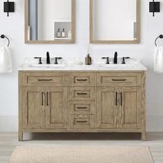 a bathroom vanity with two mirrors above it and a rug on the floor next to it