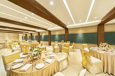 a banquet room set up with round tables and yellow linens on the tablecloths