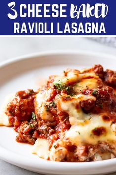 a white plate topped with lasagna covered in sauce and cheese next to a fork