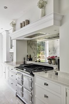 a kitchen with an oven, stove and counter tops in white cabinets on the wall