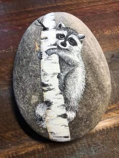 a painted rock with a raccoon on it