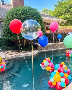 some balloons floating in the water near a pool