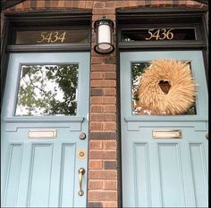 two blue front doors with the number 344 on them and a fake furry animal's head