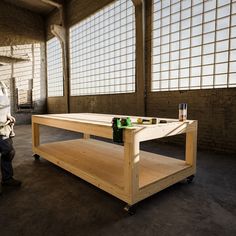 a man standing next to a table with beer bottles on it in an empty room