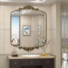 a bathroom with a large mirror above the sink and a vanity area in front of it