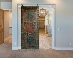 an open door leading into a room with carpeted flooring and white walls in the background