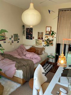 a bed room with a neatly made bed next to a laptop on a desk and a lamp