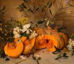 a painting of pumpkins with flowers and leaves on the table next to it,