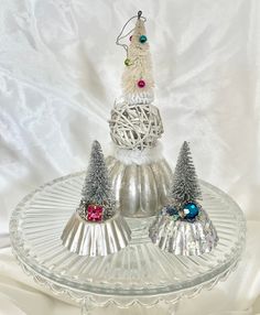 three small christmas trees sitting on top of a glass plate