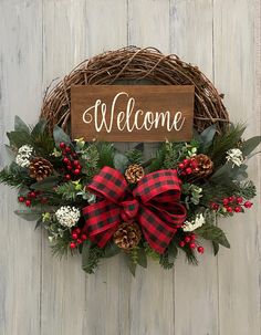 a welcome wreath with pine cones and berries