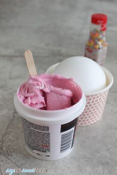 an ice cream container with pink icing in it