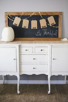 a chalkboard sign on top of a white dresser