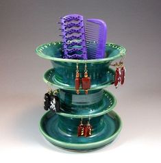 three tiered green bowl with purple hairbrushes in it