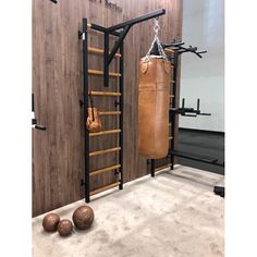 a punching bag and boxing gloves are hanging on the wall next to a gym equipment rack