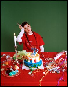 a woman sitting at a table with a birthday cake and candles in front of her