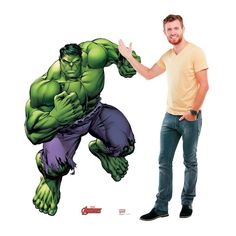 a man standing next to a giant hulk wall decal