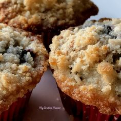 three blueberry muffins sitting on top of a white plate