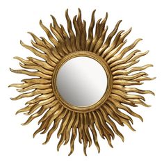 a mirror that is sitting on top of a white wall with gold leaf decoration around it