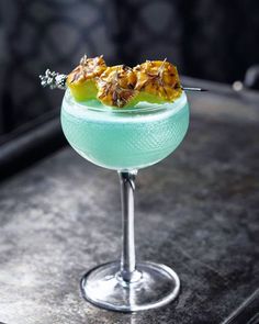 a blue cocktail with pineapple garnish on the rim