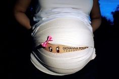 a pregnant woman holding her belly in the dark with an ad on it's side