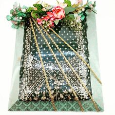 a green bag with flowers and chains on it