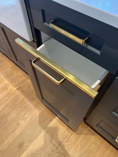 an image of a kitchen drawer that is open and has gold handles on it's doors