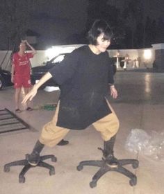 a young man riding on the back of an office chair