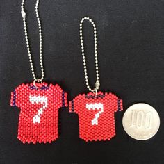 two necklaces made to look like baseball jerseys with the number seven on each one