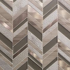 a close up view of a wall made out of silver and white tiles with metallic strips